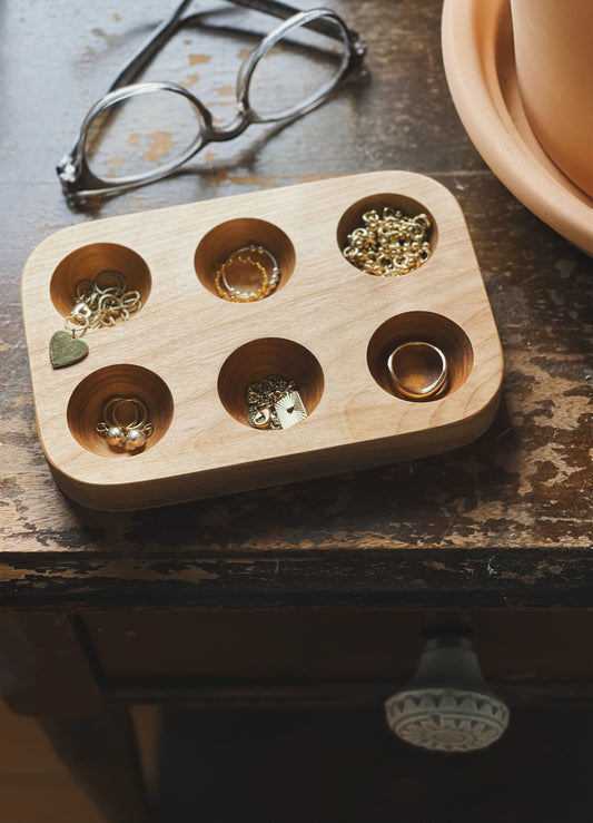 A 6 hole egg tray styled with small jewellery like rings and earrings.