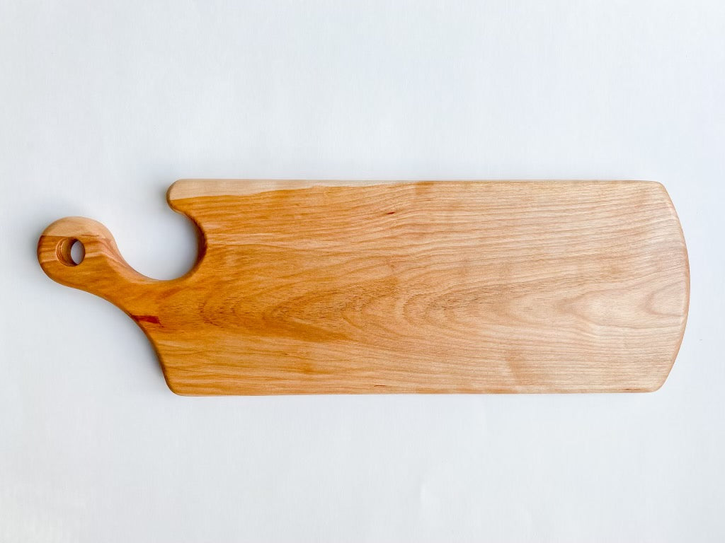 A birds eye view of the curve handle wooden cutting board.